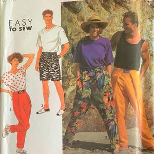 May include: Simplicity sewing pattern featuring various clothing styles. The pattern includes illustrations of a white t-shirt and zebra print shorts, a purple t-shirt and floral pants, and orange pants. The text "EASY TO SEW" is also visible.