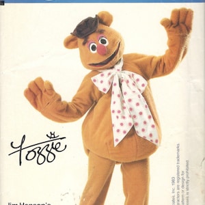May include: A brown bear costume with a white bow tie with pink polka dots. The costume is from Jim Henson's Muppet Costumes and is a Vogue Patterns Craft pattern number 8787.