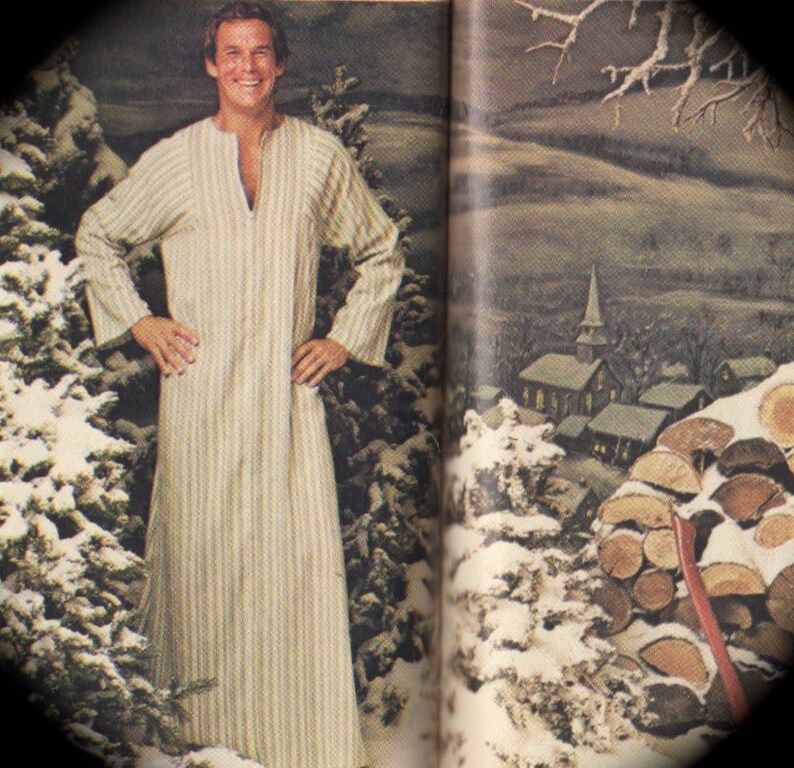 May include: A man wearing a long, striped robe with a V-neck. The robe is white and beige with vertical stripes. The man is standing in front of a snowy forest scene.