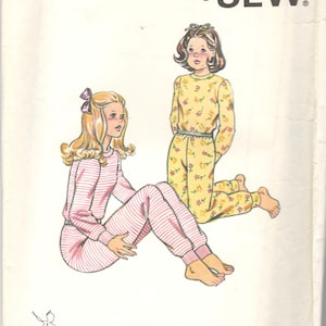 May include: A sewing pattern for pajamas with two girls wearing different styles of pajamas. The pattern is called "Kwik Sew" and the pattern number is 1057. The pattern is for sizes 8-10-12-14.