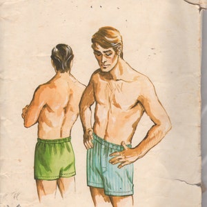 May include: A sewing pattern for men's boxer shorts. The pattern is from Kwik Sew and is for sizes 34-36-38-40. The pattern is illustrated with two men wearing the boxer shorts, one in green and one in blue and white stripes.