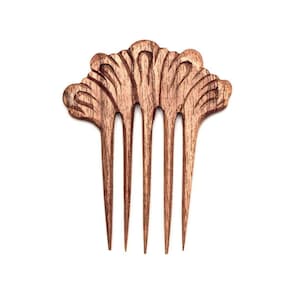 Op de afbeelding: Een houten haar kam met een decoratief bloemenontwerp. De kam heeft vijf tanden en is gemaakt van lichtbruin hout.