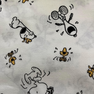 May include: White fabric with a repeating pattern of Snoopy and Woodstock cartoon characters in black and yellow. Snoopy is depicted in various playful poses, while Woodstock is shown in a distressed state.