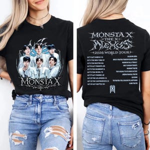 May include: A black t-shirt featuring a graphic of the group Monsta X on the front with the text Monsta X. The back of the shirt displays the text Monsta X The X Nexus 2026 World Tour followed by a list of tour dates and locations in white.