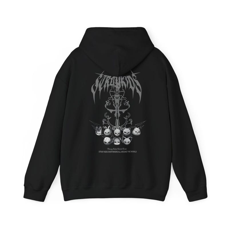 Puede incluir: Sudadera con capucha negra con un dise&ntilde;o gr&aacute;fico en la espalda. El dise&ntilde;o presenta la palabra "Stray Kids" en una fuente estilizada sobre un emblema central y varias caras de animales de dibujos animados. Tambi&eacute;n es visible el texto "STRAY KIDS EVERYWHERE ALL AROUND THE WORLD".
