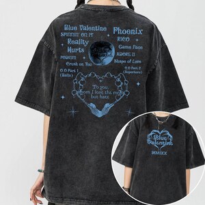May include: Dark gray t-shirt with short sleeves featuring blue text and graphics. The back of the shirt has a heart-shaped design with the words "To you, whom I love the most but hate." The front has "Blue Valentine" and "SUMIXX".