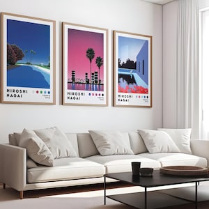 Op de afbeelding: Drie ingelijste prints met een retro-ontwerp met een zwembad en palmbomen. De prints zijn getiteld "Hiroshi Nagai" en hebben een kleurenpalet van blauw, roze en groen.