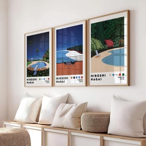 Op de afbeelding: Drie ingelijste prints van een zwembadsc&egrave;ne met de tekst "HIROSHI NAGAI TOKYO 1973" onderaan elke print.