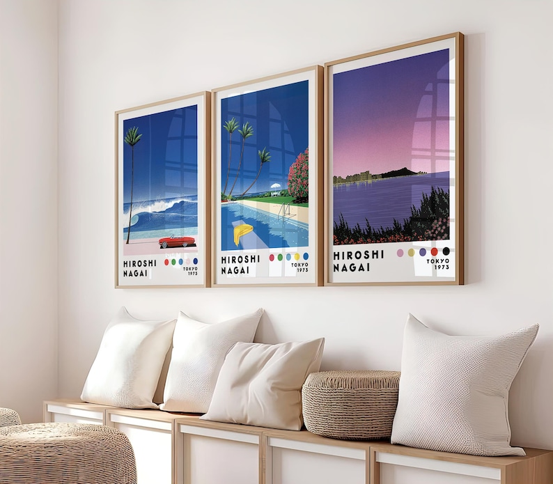 Op de afbeelding: Drie ingelijste prints met een retro-esthetiek. Elke print toont een andere sc&egrave;ne met een blauw, paars en roze kleurenschema. De prints zijn getiteld "Hiroshi Nagai" en bevatten de tekst "Tokyo 1975".