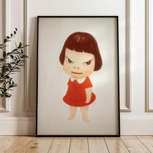 Puede incluir: Lámina artística enmarcada que presenta una ilustración de dibujos animados de una niña con expresión enfadada. La niña tiene el pelo corto castaño, ojos verdes y viste un vestido rojo con cuello blanco. La obra está enmarcada en un marco negro.