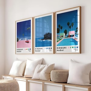 Op de afbeelding: Drie ingelijste prints met een retro-esthetiek met een strandscene, een palmboom en een zwembad met een gebouw op de achtergrond. De prints zijn allemaal van Hiroshi Nagai en zijn getiteld "Tokyo 1973".