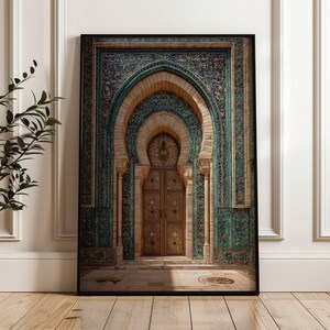 May include: Framed print of an ornate arched doorway with intricate tilework in teal and gold. The doorway features a detailed wooden door and is framed by beige columns and arches. The artwork is displayed on a wooden floor.