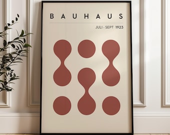 May include: A poster with the text "BAUHHAUS JULI - SEPT 1923" in black text on a cream background. The poster features a geometric design of six red circles with a teardrop shape in the center of each circle.