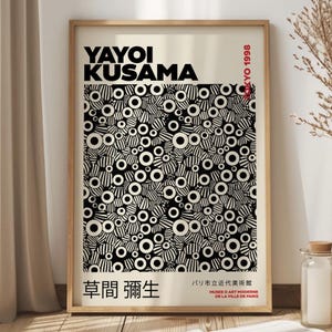Może przedstawiać: Czarno-biały plakat z powtarzającym się wzorem kół i pasków. Plakat zawiera tekst "YAYOI KUSAMA" i "草間彌生" w języku japońskim. Tekst "TOKYO 1998" jest również widoczny w prawym górnym rogu plakatu.