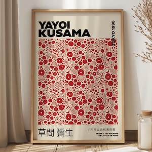 May include: A framed art print featuring the name "YAYOI KUSAMA" in bold black letters. The artwork showcases a pattern of red circles on a cream background. Additional text includes "TOKYO 1998" and Japanese and French text. The print is in a wooden frame.