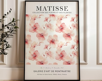 May include: A black and white poster with the text "MATISSE COLLECTION DES FLEURS ET DES PLANTES" at the top. The poster features a watercolor painting of pink flowers on a white background. The text "GALERIE D'ART DE MONTMARTRE" and the address "83 Rue Le Gare Nord, 75942, Paris, France" are at the bottom of the poster.