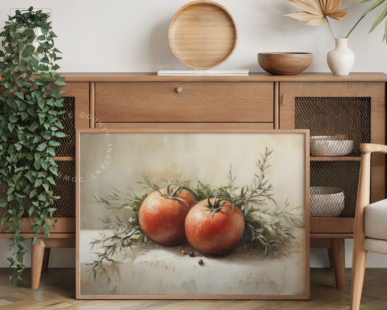 Pu&ograve; includere: Stampa incorniciata con una natura morta di due pomodori rossi maturi e rametti verdi. L'opera d'arte ha un'estetica vintage, con illuminazione soffusa e uno sfondo neutro. I pomodori sono il punto focale.