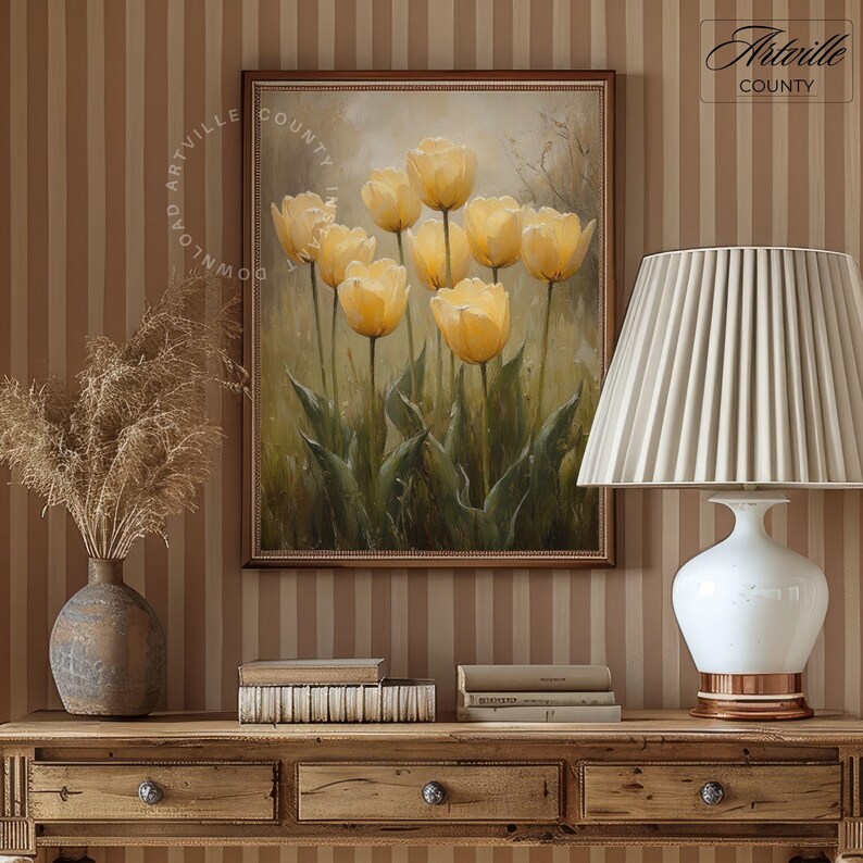 May include: A framed painting of yellow tulips in a vase with a blurred background. The painting is hanging on a wall with brown and white striped wallpaper.