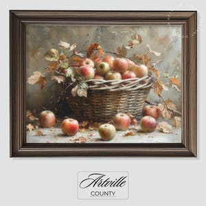 Può includere: Dipinto con cornice di natura morta che raffigura un cesto di vimini traboccante di mele rosse e verdi. Foglie e rami autunnali circondano il cesto, con diverse mele sparse alla base. La cornice è di colore marrone scuro. Il dipinto è firmato "Artville County".