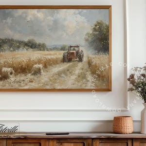 Puede incluir: Una pintura de paisaje enmarcada representa un tractor rojo cosechando trigo en un campo bajo un cielo nublado. La obra de arte presenta balas de heno y p&aacute;jaros, con una c&aacute;lida paleta de colores marrones, amarillos y azules. La pintura est&aacute; en un marco de madera.