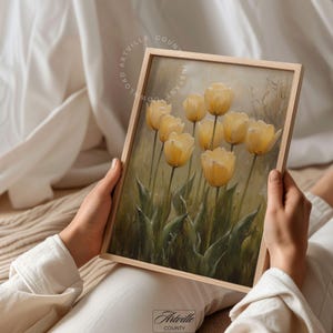 May include: A painting of a bouquet of yellow tulips with green leaves against a soft, blurred background.