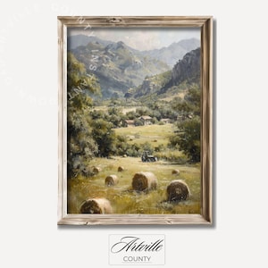 Può includere: Un dipinto incorniciato di un paesaggio rurale con colline ondulate, una valle e un piccolo villaggio. Il dipinto presenta un trattore in un campo con balle di fieno sparse ovunque. Il dipinto è in una cornice di legno rustica.