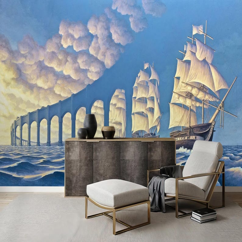 Puede incluir: Un dise&ntilde;o de interior de sala de estar con un sill&oacute;n y un reposapi&eacute;s blancos, un gabinete de madera oscura y un mural de pared que representa una escena surrealista de barcos navegando bajo un puente en un cielo nublado.