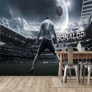 May include: A digitally enhanced image of a soccer player in a stadium, with a futuristic space-themed background. The player is wearing a grey jersey with the number 7. The stadium has the text "CRISTIANO RONALDO" and "THE BEST IN THE WORLD".