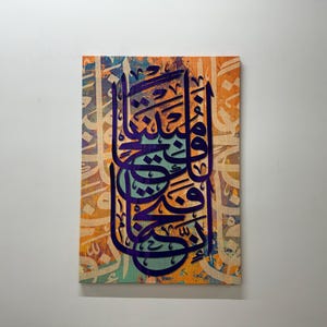 Puede incluir: Una pintura de lienzo colorida con caligraf&iacute;a &aacute;rabe en morado sobre un fondo naranja, azul y verde.