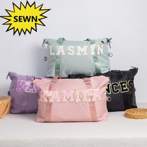 Puede incluir: Una colección de bolsas de lona personalizadas en varios colores: verde claro, morado, rosa y negro. Cada bolsa presenta un nombre en una fuente de estilo universitario. La palabra "SEWN" se muestra en una estrella amarilla.