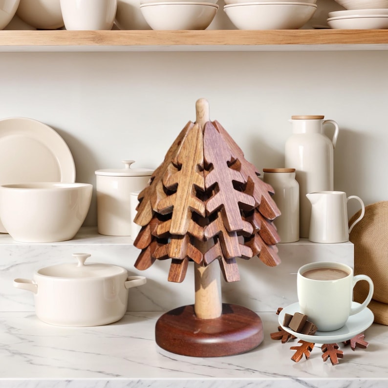 May include: A wooden tree-shaped coaster set with a brown and natural wood finish. The set includes a large tree-shaped coaster and several smaller leaf-shaped coasters.