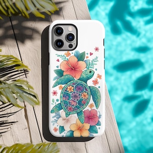 May include: White phone case featuring a teal sea turtle with a floral design. The turtle's shell has a geometric pattern with colorful flowers. Hibiscus and other flowers in shades of pink, orange, and white surround the turtle. The case has a black border and a camera cutout.