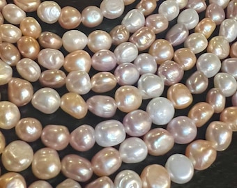 May include: A multi-strand necklace made of baroque pearls in shades of white, pink, and peach. The pearls are irregular in shape and have a lustrous finish.