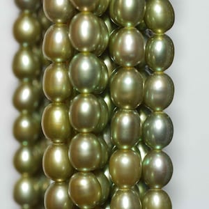 May include: A strand of green freshwater pearls. The pearls are round and have a smooth, iridescent surface.