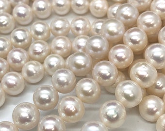 May include: A strand of white pearls, each pearl is round and smooth. The pearls are arranged in a loose, flowing pattern.
