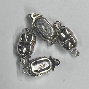 May include: Three silver-toned magnetic clasps for jewelry making. The clasps are oval-shaped with a textured surface and have a small loop on one end. The clasps are marked with the text "925".
