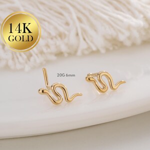 Könnte beinhalten: Ein Paar 14 Karat Goldschlangen-Ohrstecker. Die Ohrringe sind 6 mm groß und aus 20 Gauge Gold gefertigt.