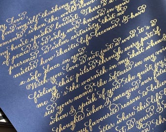 Carta personalizada con caligrafía floreciente en tinta dorada: votos matrimoniales escritos a mano en papel azul marino.