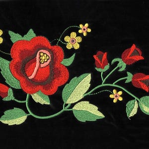 Può includere: Ricamo floreale con una grande rosa rossa, rose rosse più piccole e fiori gialli su sfondo nero.