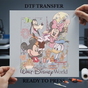 May include: A DTF transfer sheet featuring Mickey Mouse, Minnie Mouse, Goofy, and Donald Duck with the text "Walt Disney World" and "Ready to Press". The design includes iconic landmarks and fireworks, all in a colorful cartoon style.