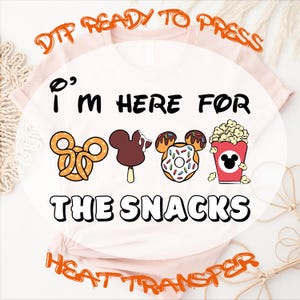 May include: A light pink t-shirt featuring the text "I'M HERE FOR THE SNACKS" in black, accompanied by four snack icons: a pretzel, a chocolate-covered ice cream bar, a donut, and a popcorn bucket, all shaped like Mickey Mouse ears.