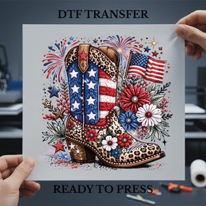 May include: DTF transfer sheet featuring a patriotic cowboy boot design. The boot is decorated with the American flag, stars, and floral accents. The text "DTF TRANSFER" and "READY TO PRESS" are displayed.