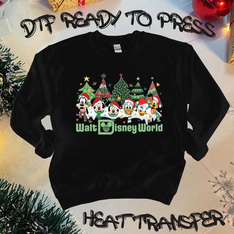 May include: Black sweatshirt with a Christmas-themed design featuring Mickey Mouse, Donald Duck, Goofy, and Pluto in front of Christmas trees. The text "Walt Disney World" is printed below the characters.