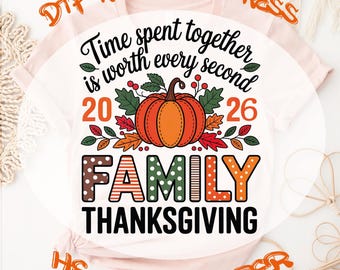 May include: A light pink t-shirt featuring a graphic with the text "Time spent together is worth every second", "2026", "FAMILY", and "THANKSGIVING". The design includes a central orange pumpkin surrounded by green leaves and red berries.