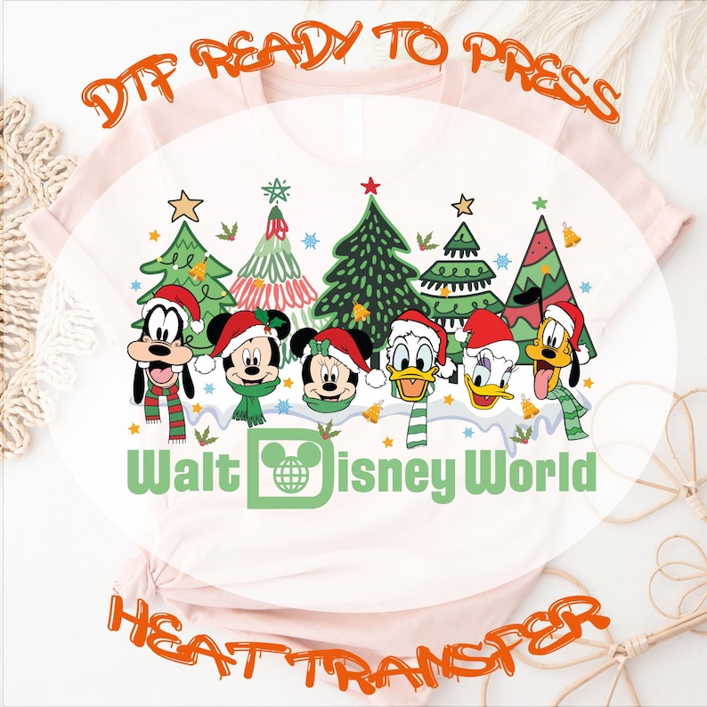 DTF ready-to-press heat transfer featuring a Christmas-themed design.  The design showcases Goofy, Mickey Mouse, Minnie Mouse, Donald Duck, and Daisy Duck in Santa hats, positioned in front of stylized Christmas trees.  The text 'Walt Disney World' is prominently displayed below the characters. The design is on a light pink shirt.  This is a digital design for heat transfer onto apparel.
