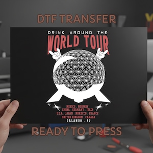 May include: Black DTF transfer with the text "DRINK AROUND THE WORLD TOUR" in red and white. The design includes a geometric globe and the words "READY TO PRESS". The transfer lists several countries and Orlando, FL.