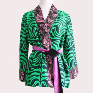 Può includere: Un kimono a stampa zebra verde e nero con fodera floreale rosa e una cintura rosa e nera.
