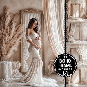 May include: A pregnant woman in a white lace gown poses in a studio setting with a backdrop of sheer white curtains and a large ornate mirror. The backdrop features a rustic wooden shelf with framed artwork and dried pampas grass.