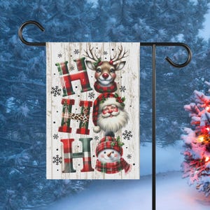 May include: A white wooden sign with the word "HO HO HO" in red, black, and white plaid. The letters are decorated with a reindeer, Santa Claus, and a snowman.