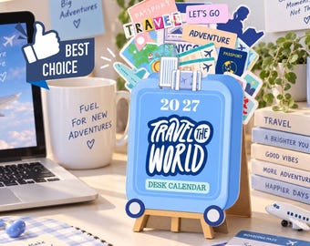 May include: A 2027 desk calendar shaped like a light blue suitcase with the text Travel The World. The calendar features a pop-up design with various travel-themed illustrations including passports, airplanes, and luggage, all displayed on a small wooden easel stand.